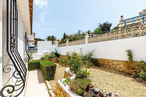 Stunning garden area with a variety of plants and shrubs, surrounded by a low wall and white fence.