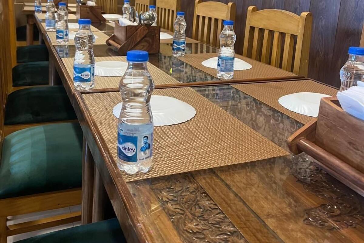 A conference room with a long table, chairs, water bottles, and a patterned wall.