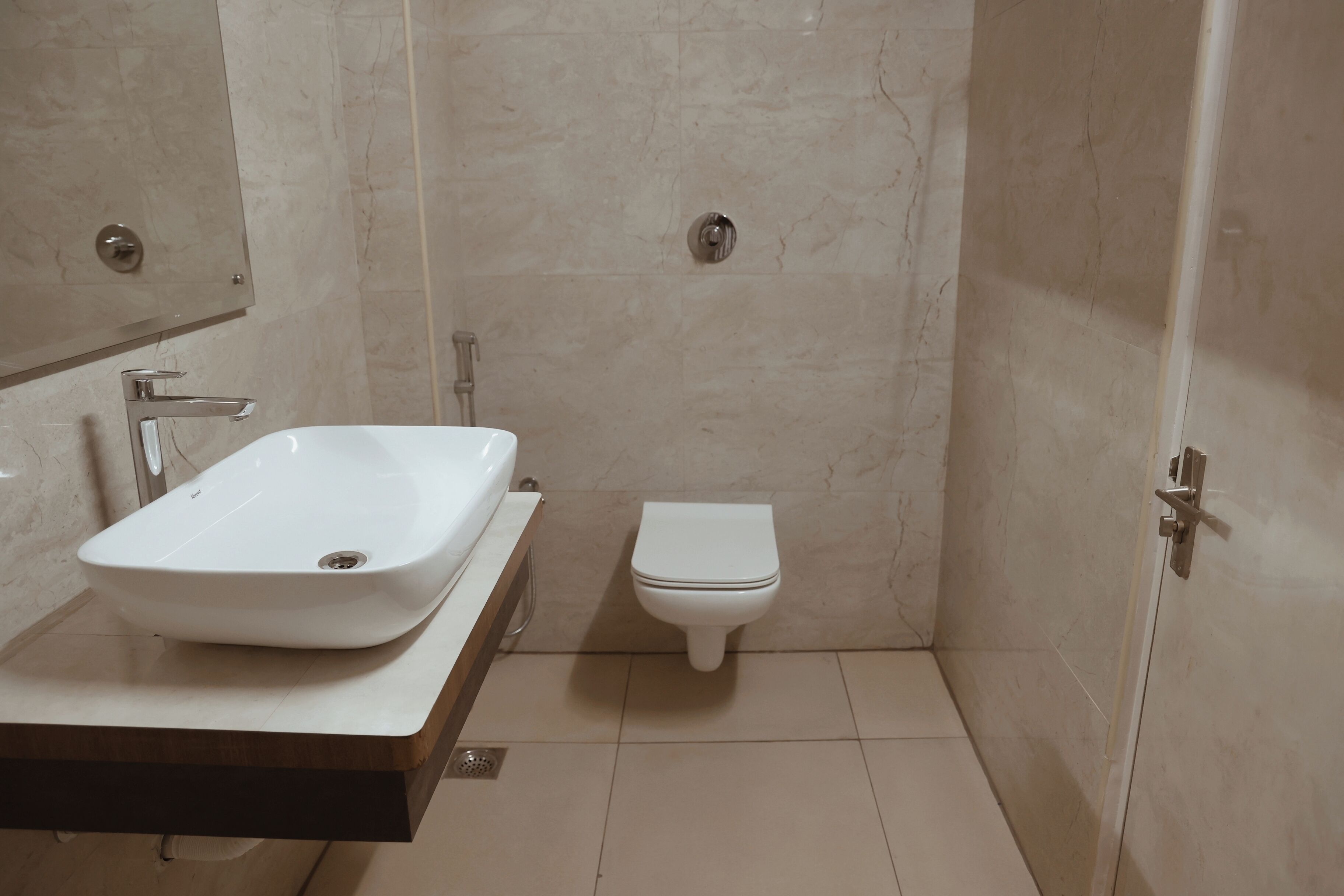 A bathroom with a white sink, toilet, and a mirror above the sink.
