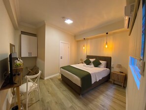 A hotel room with a bed, bedside tables, a desk with a chair, a mirror, and a wardrobe. - PRUVA INN HOTEL (Antalya)