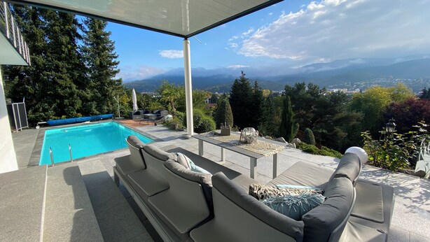 A modern outdoor pool area with a view of a mountainous landscape. - Modern vacation apartment with view and pool near Baden Baden in the Black Forest  (Gernsbach)