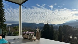 A terrace with a table, a basket of flowers, and a decorative starfish. - Modern vacation apartment with view and pool near Baden Baden in the Black Forest  (Gernsbach)