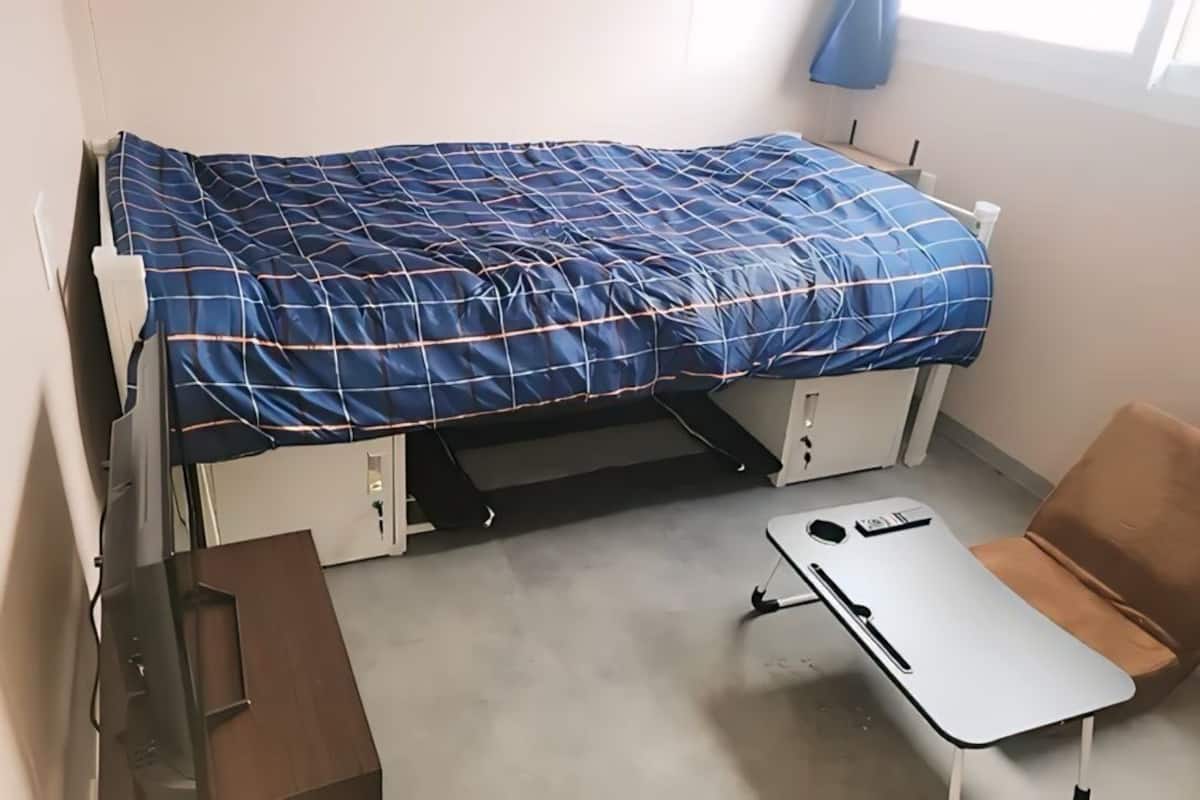 A compact room with a bed, a desk, and a chair.