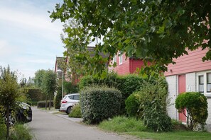 Stroll through a serene residential neighborhood surrounded by lush greenery and beautifully maintained gardens.
