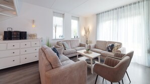 Ein modernes Wohnzimmer mit einer Sofagarnitur, einem Couchtisch und einer weißen Kommode.