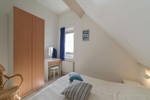 A bedroom with a bed, a desk, a chair, and a wardrobe. - Family Home near Beaches (Wemeldinge)