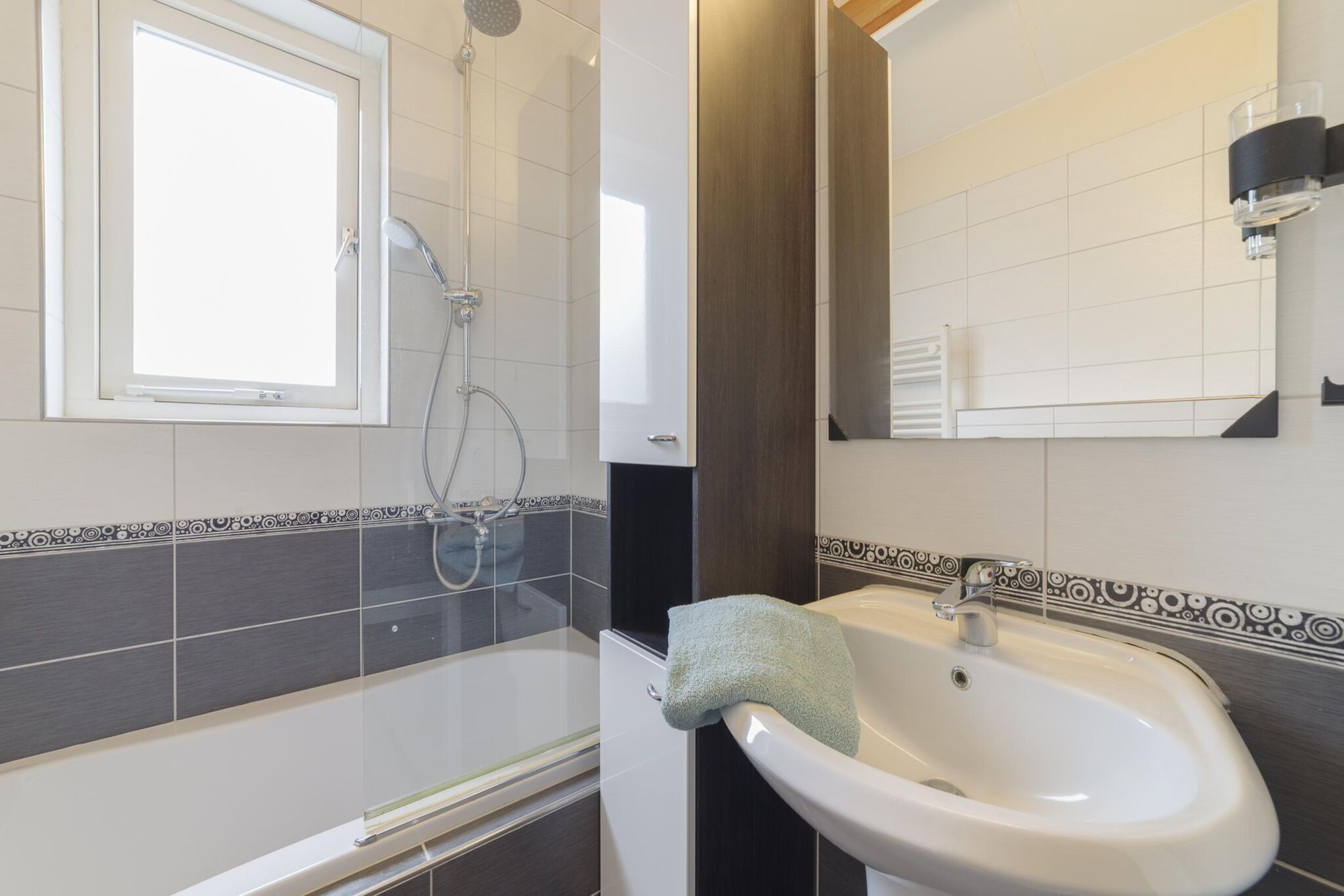 A bathroom with a shower, a sink, and a mirror.