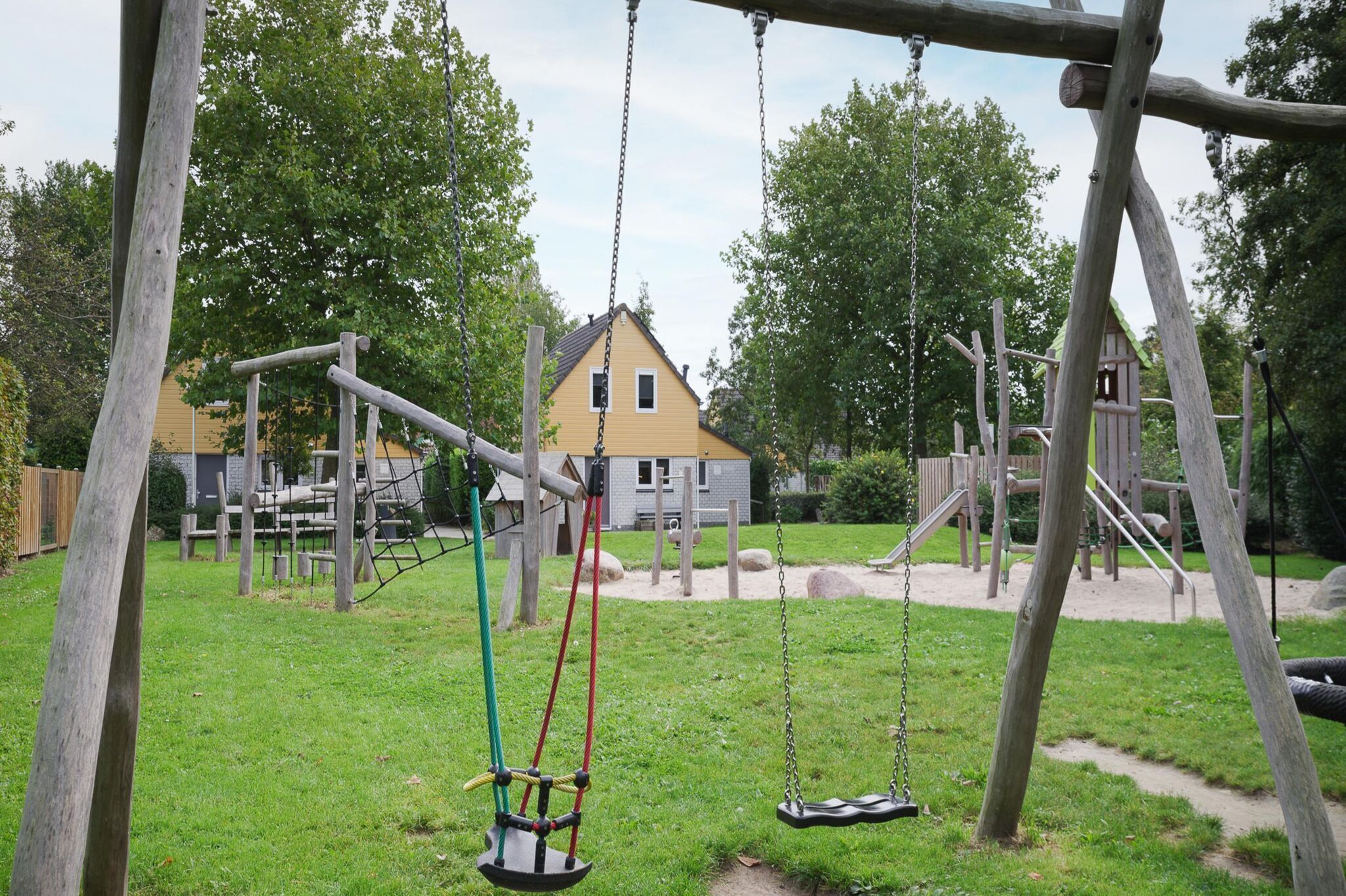 Une aire de jeux avec des balançoires et des structures d’escalade.