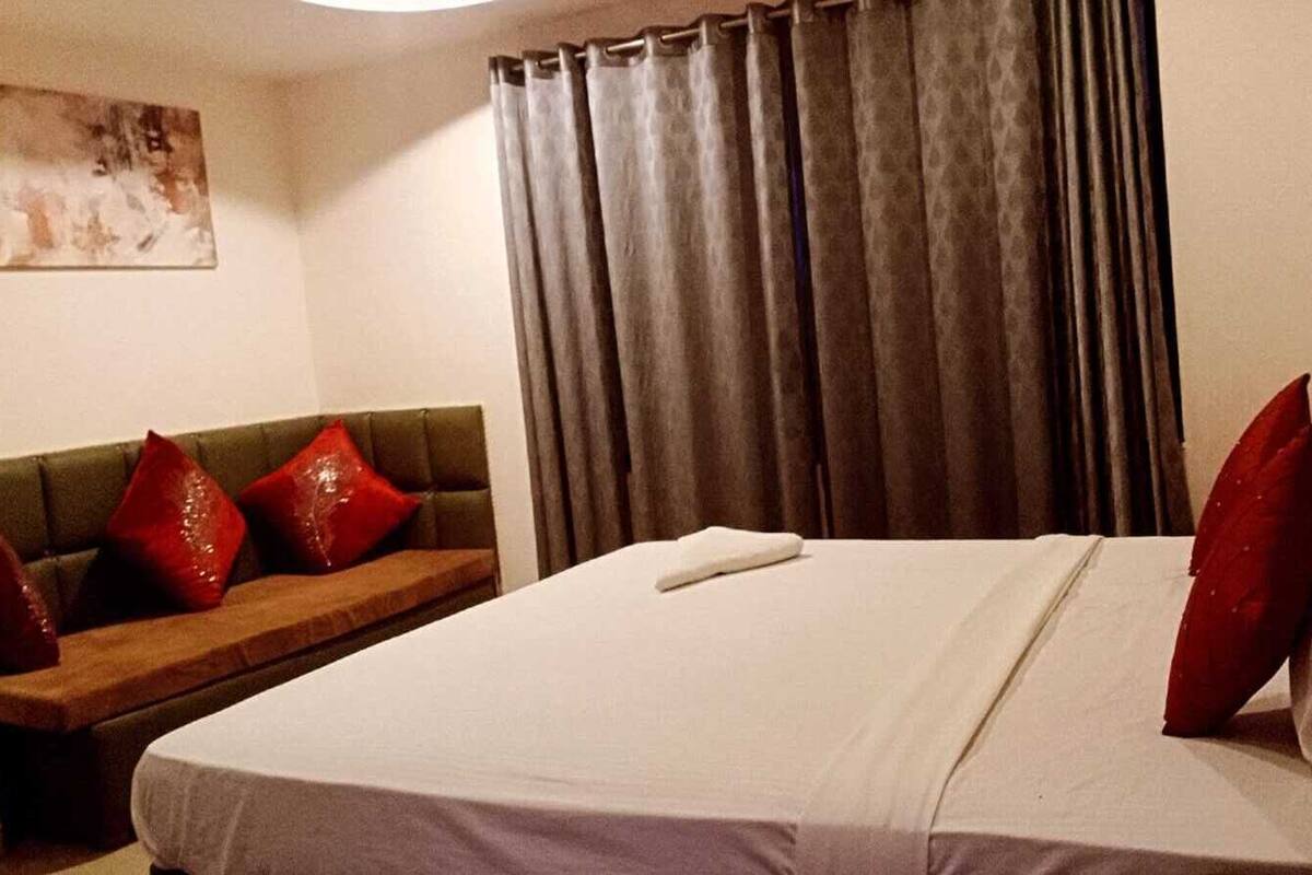 Una habitación de hotel con cama, sofá y un cuadro en la pared.