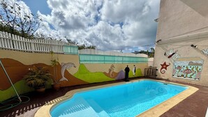 A swimming pool with a tiled edge, surrounded by a paved area. - Villa Poisson Dans l 'eau (Trou aux Biches)
