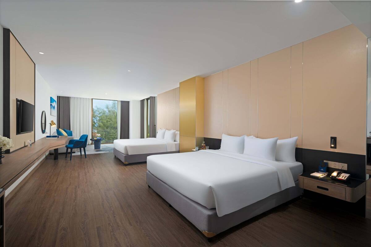 Una habitación de hotel moderna con dos camas, un escritorio y una silla.