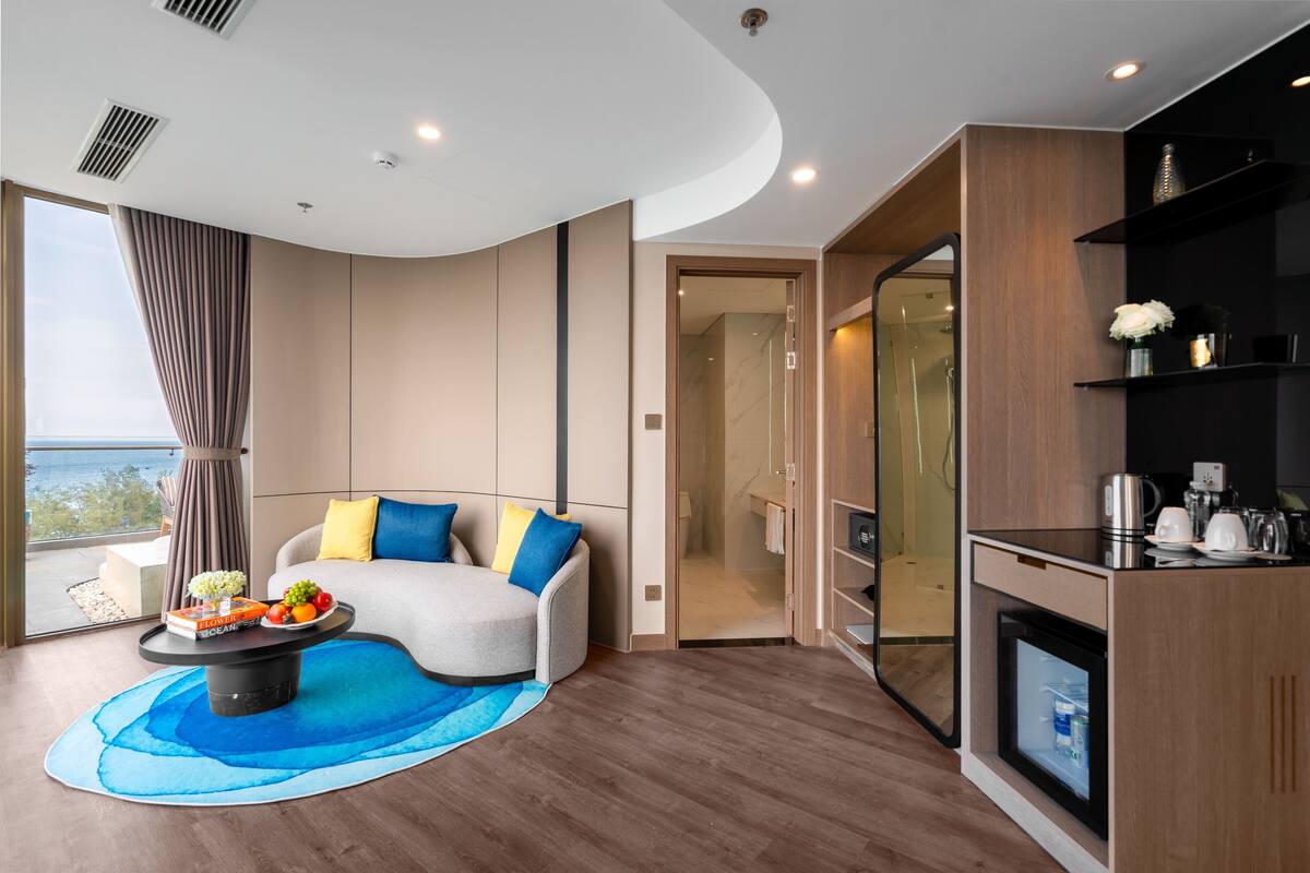 Una sala de estar moderna con un sofá, una mesa de centro y vista al mar.