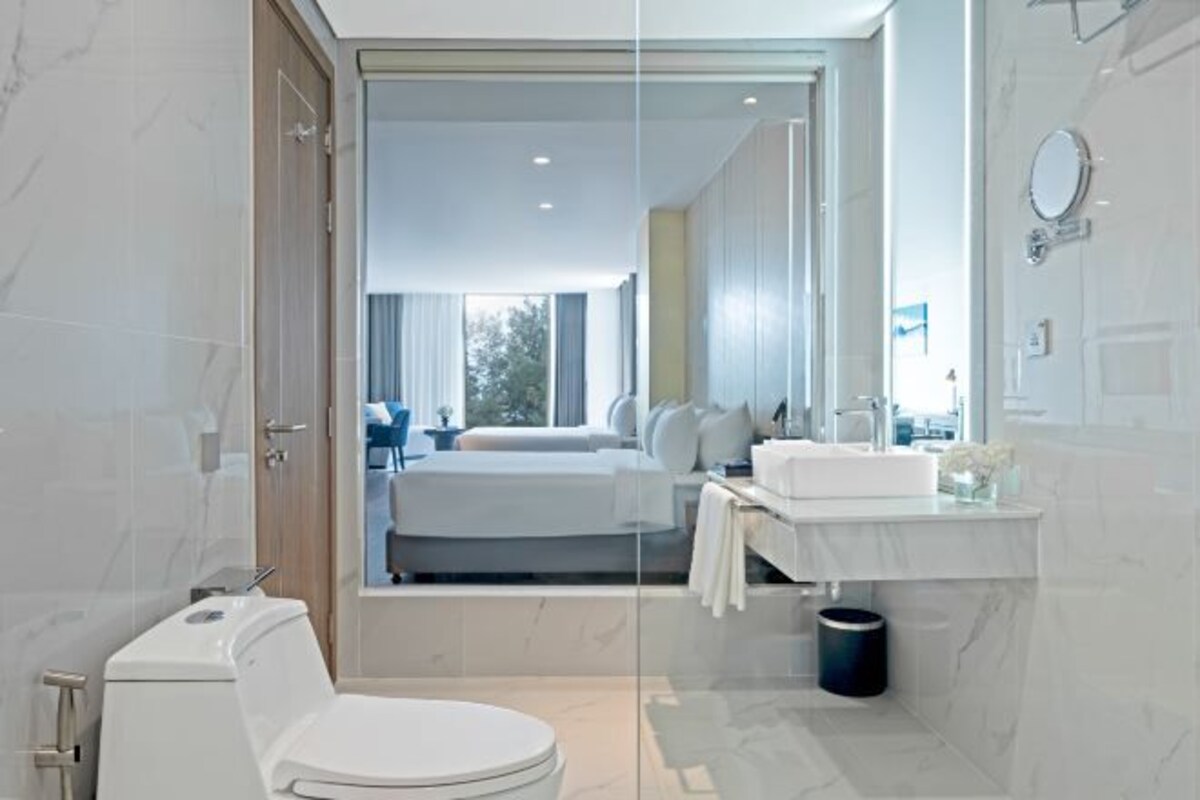 Un baño moderno con inodoro, lavamanos y espejo.
