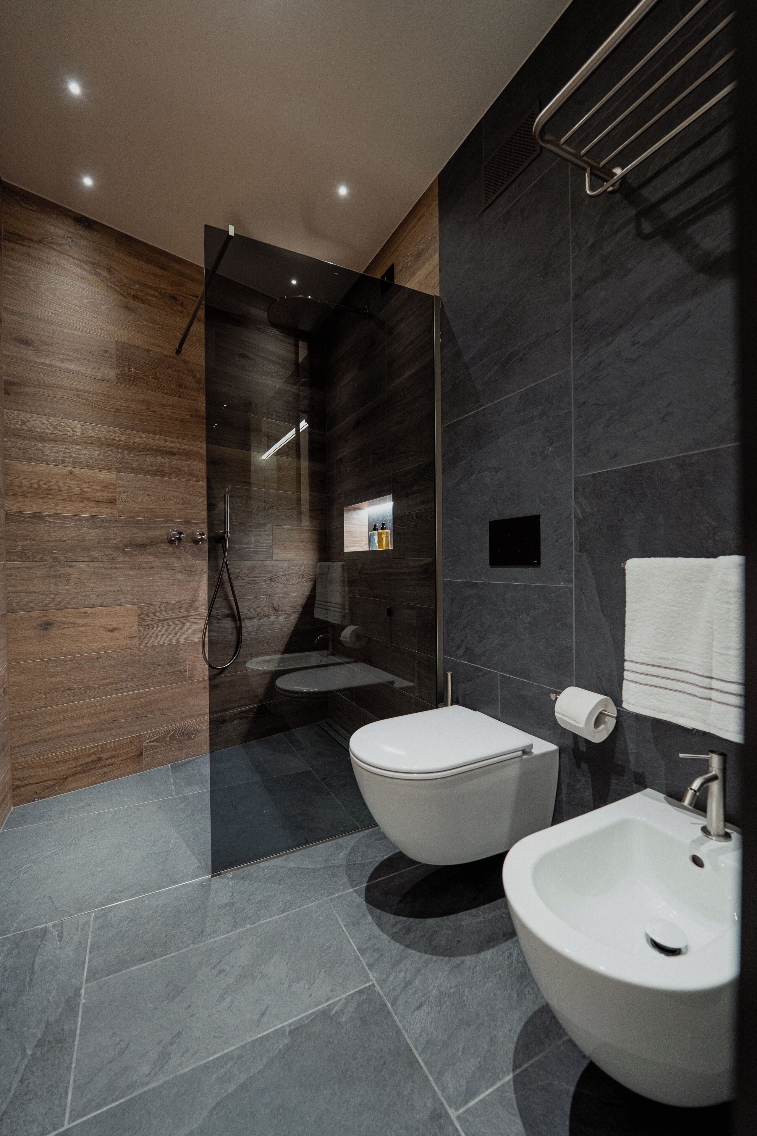 Un baño moderno con ducha envuelta en vidrio, inodoro y bidé.