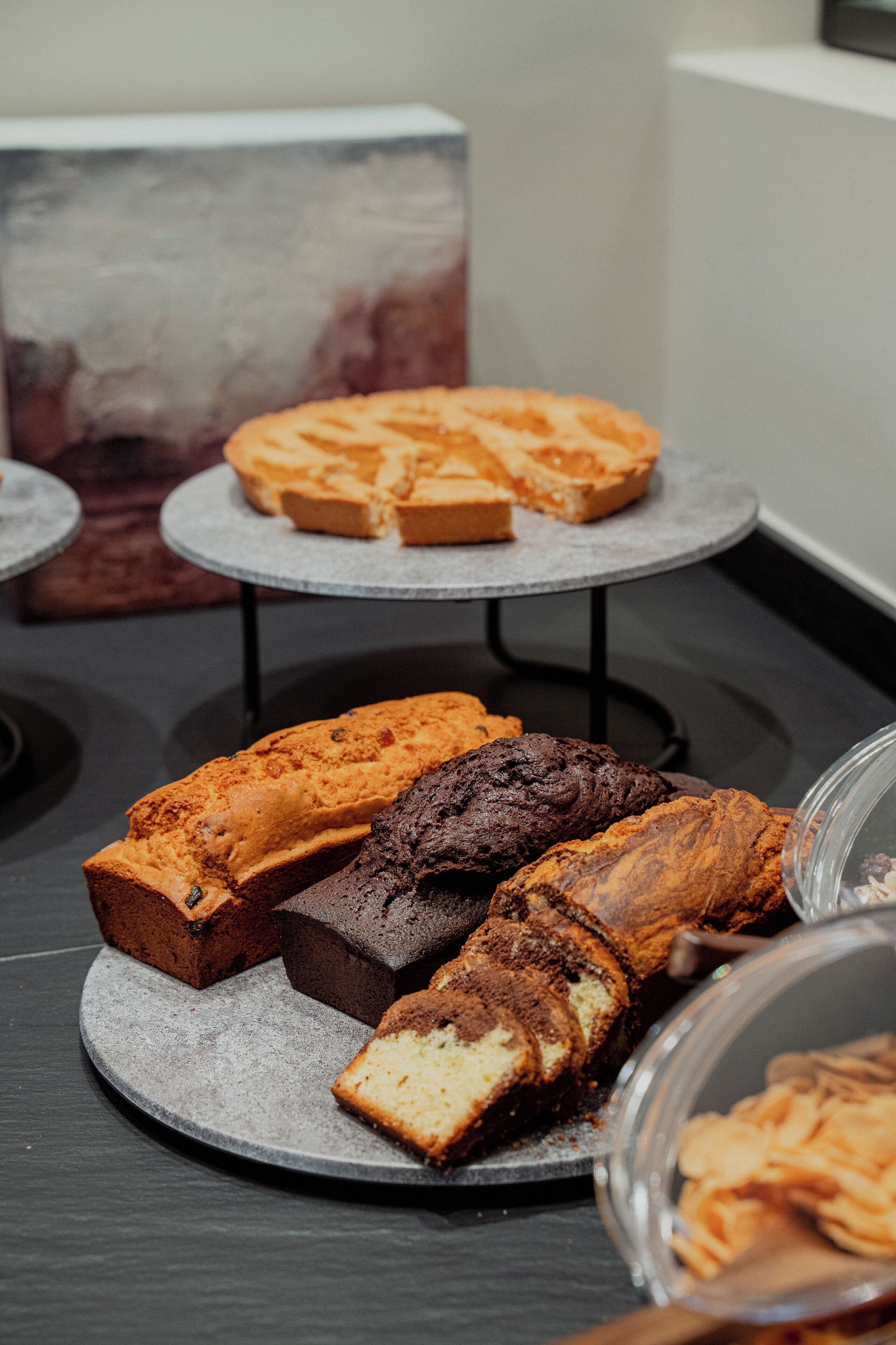 Una exhibición de productos horneados sobre una mesa, incluyendo distintos tipos de pan y pasteles.