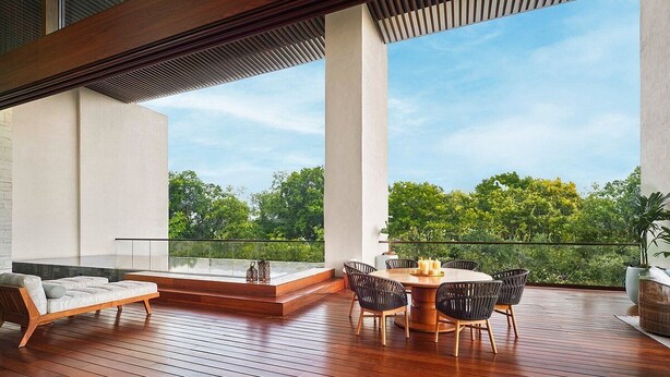 A spacious balcony with a wooden deck, a round table with chairs, and a sofa. - 2 Bedroom Estates 5 Diamonds, VIP Golf Tournament, VIP Park Access Vidanta World (Nuevo Vallarta)