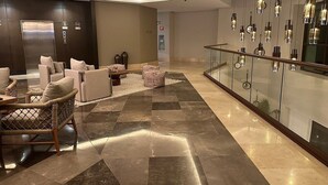 A modern lobby with a seating area, a glass railing, and a polished floor. - 2 Bedroom Estates 5 Diamonds, VIP Golf Tournament, VIP Park Access Vidanta World (Nuevo Vallarta)