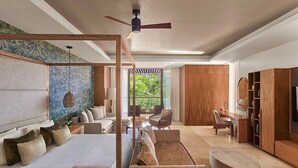 A modern bedroom with a large bed, a sitting area with a sofa and chairs, a wooden wardrobe, and a view of greenery through the window. - 2 Bedroom Estates 5 Diamonds, VIP Golf Tournament, VIP Park Access Vidanta World (Nuevo Vallarta)