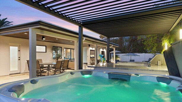 A modern outdoor hot tub area with a covered patio, seating, and a pool. - Bella Palma: Elegance & Style w/Putt, Pool & Spa! (Scottsdale)