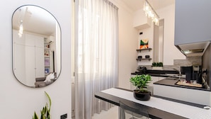 A modern kitchen with a dining area, a large mirror, and a potted plant. - VivimiHome - Rifugio Chic a Milano Buenos Aires (Milano)