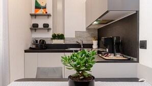 A modern kitchen with a central island, a coffee machine, and a potted plant. - VivimiHome - Rifugio Chic a Milano Buenos Aires (Milano)