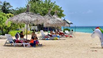 Na praia, areia branca, toalhas de praia