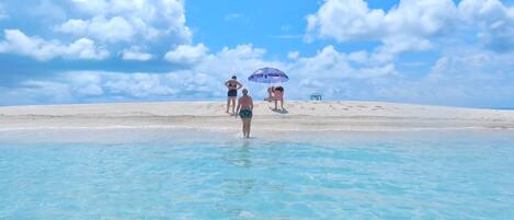 A beach with clear turquoise water and a sandy shore.