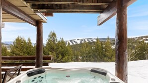 A hot tub with a view of snow-capped mountains and pine trees. - Ski-In/Ski-Out via Pony Express Lift (Big Sky)