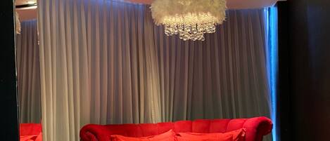 A bedroom with a large bed, a mirror, and a chandelier.
