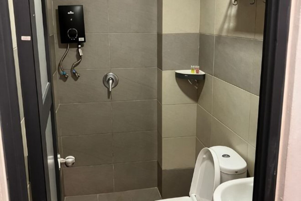 Een badkamer met een douche, toilet en een plank met toiletartikelen.