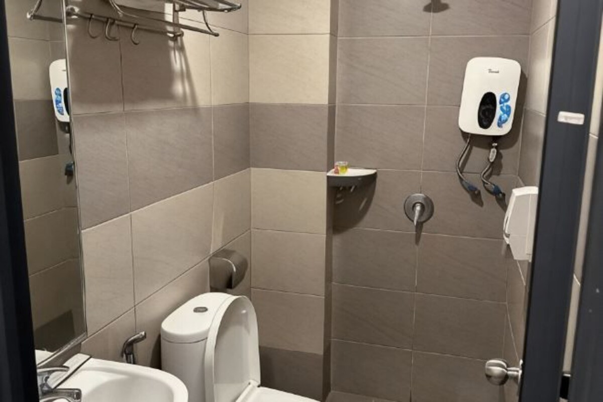 Une salle de bain équipée de toilettes, d’un lavabo et d’un sèche-mains.