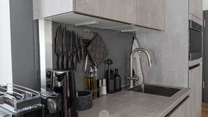 A modern kitchen with a stainless steel sink, a coffee machine, and a knife block. - Perfect city center location, 107 sqm, directly at the opera house in suite flair with balcony! (Nürnberg)