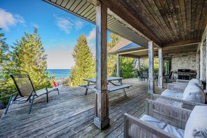 Une terrasse extérieure couverte, dotée d’un plancher en bois, de tables de pique-nique et de sièges confortables.