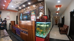 Een receptiebalie met een aquarium, een klok en een kalender aan de muur.