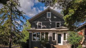 A two-story house with a front porch, large windows, and a stone facade. - Charming Family Home Steps from UWSP & Downtown (Stevens Point)