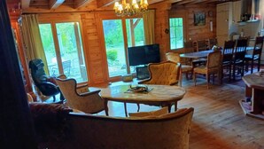 A cozy wooden interior with a dining area, a television, and comfortable seating.