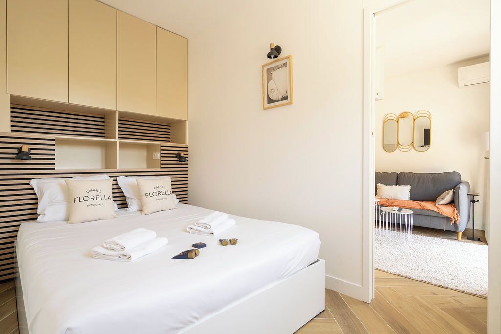 Ein Hotelzimmer mit einem großen Bett, einem Kleiderschrank, einem kleinen Tisch und einer Couch im angrenzenden Wohnbereich.