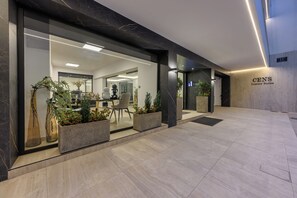 A modern hotel entrance with glass doors, indoor plants, and a sign for 'CENS Luxury Suites'. - Cens Silver Suites (Ioannina)