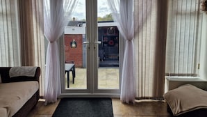 A room with a sliding glass door leading to an outdoor area with a table and chairs. - 3 Bedroom - 1 Bathroom - Garden - Pet Friendly (Wrexham)