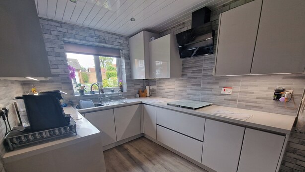 A modern kitchen with white cabinetry, a built-in oven, and a window with a view of greenery. - 3 Bedroom - 1 Bathroom - Garden - Pet Friendly (Wrexham)