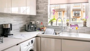 A modern kitchen with a coffee maker, toaster, and washing machine. - 3 Bedroom - 1 Bathroom - Garden - Pet Friendly (Wrexham)