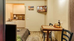 A compact living space with a kitchenette, a dining area, and a bed. - Florence House San Zanobi (Firenze)