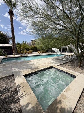 A swimming pool with a hot tub, surrounded by a patio area with lounge chairs and a pergola. - The Knot - The Ultimate Palm Springs Bungalow (Palm Springs)