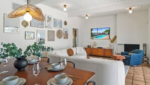 Una sala de estar moderna con comedor, paredes blancas y chimenea.