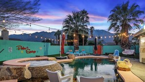 Uima-allas, jossa on aurinkotuoleja, poreallas ja tunnelmavalaistuksena käytetyt valonauhat, ja taustalla kohoava vuoristo.