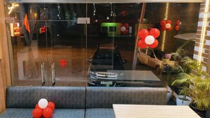 A hotel lobby with a seating area, a reception desk, and a view of the street outside. - Hotel Kashni (Maihar)