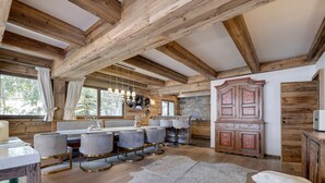 A rustic kitchen with wooden beams, a stone wall, and a large wooden cabinet. - Ski-in/ski-out chalet with pool and sauna in Val-d'Isère (Val-d'Isère)
