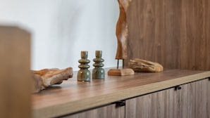 A wooden shelf with various objects including a carved wooden figure, two small candle holders, and a piece of driftwood. - Renovated duplex in center with parking and wifi (La Plagne Montalbert)