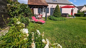 A house with a garden, a red umbrella, and a lawn chair. - Peaceful Berry retreat with garden and fireplace (Brives)
