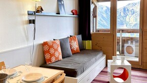 A cozy room with a bed, a dining table, and a window with a mountain view. - Comfortable 2-room apartment with panoramic view in Avoriaz (Avoriaz)